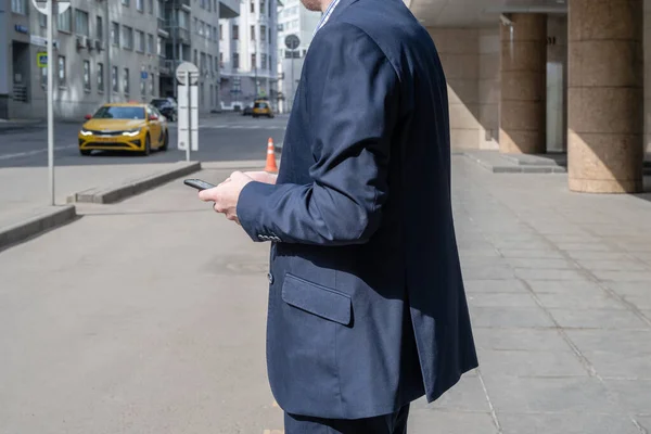 Egy Öltönyös Üzletember Taxit Foglalt Utcán Álló Mobiltelefon Alkalmazással Sárga — Stock Fotó