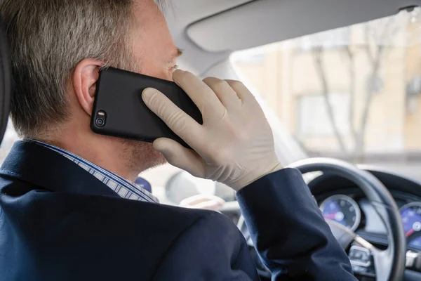 Μεσήλικας Που Τηλεφωνεί Στο Τηλέφωνο Λαστιχένια Γάντια Ενώ Οδηγεί Αυτοκίνητο — Φωτογραφία Αρχείου