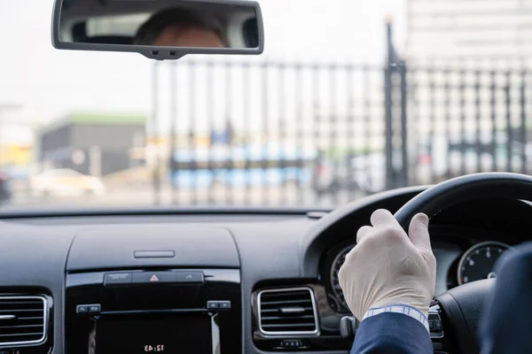 自動車を運転する細菌およびウイルスから身を守るための青いスーツおよびゴム手袋の中世のビジネスマン 鉄門を開ける前の男性ドライバーが乗車の準備ができています コロナウイルス パンデミック — ストック写真