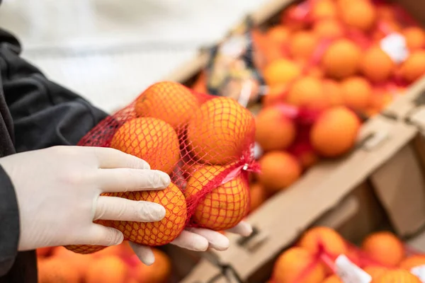 穿着橡胶防护手套的男性顾客在杂货店 超市里购买橙色 在大肠病毒大流行期间对细菌和病毒的保护 — 图库照片