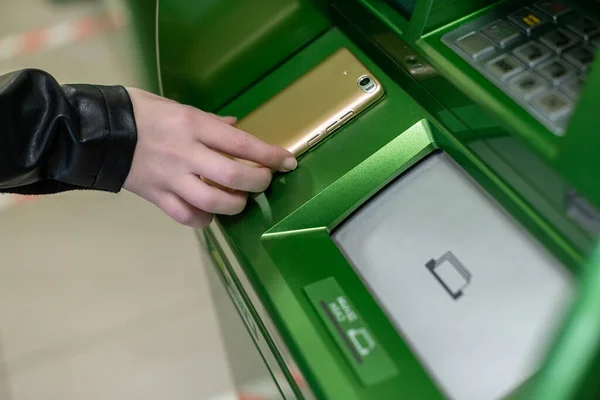 stock image Woman withdrawing money from atm with a mobile phone a NFC terminal