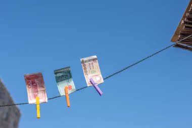 Güneydoğu Asya 'nın parası. Mavi gökyüzünün karşısındaki ipte bir mandal var. Çin Yuanı (CNY) para birimi, Endonezya, Malezya, Tayland. Seyahat, turizm, sigorta. konsept