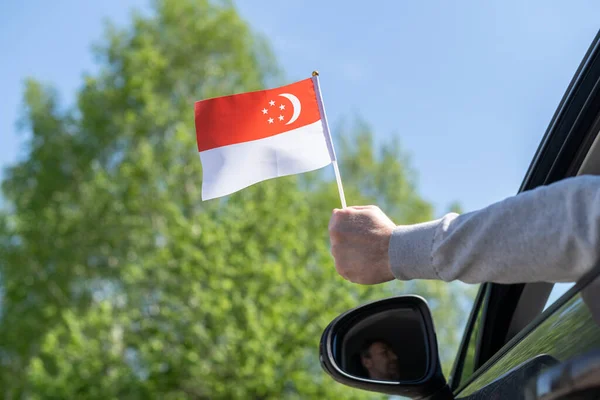 オープンカーの窓からシンガポール国旗を掲揚している男 コンセプト — ストック写真