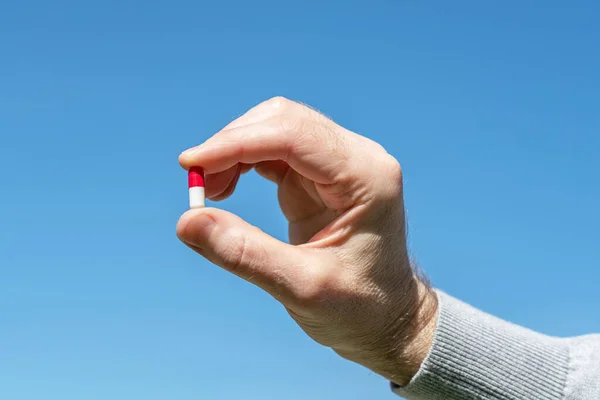 Man Håller Sitt Handpiller Den Blå Himlen Bakgrund Botemedlet Mot — Stockfoto