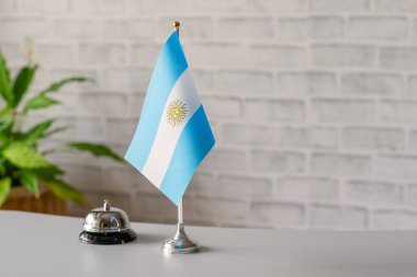 Arjantin 'in ulusal bayrağıyla gümüş antika çan resepsiyonda fotokopi alanı ile birlikte. Otel servisi. Seyahat, turizm. Güney Amerika, kavram.