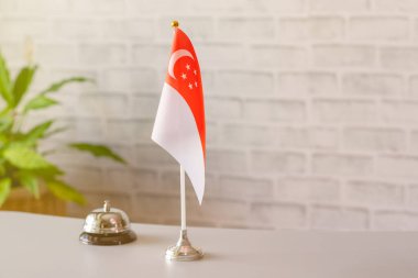 Singapur 'un ulusal bayrağı resepsiyonda fotokopi masalı gümüş antika çan. Otel servisi. Seyahat, turizm. Seçici odaklanma. Asya, Kavram.