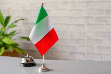 İtalya 'nın ulusal bayrağı resepsiyonda fotokopi masalı gümüş renkli zil. Otel servisi. Seyahat, turizm. Seçici odaklanma. Avrupa, Kavram.