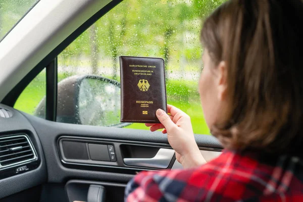 Επιβάτισσα Που Κρατάει Γερμανικό Διαβατήριο Κάθεται Στο Αυτοκίνητο Για Ελέγξει — Φωτογραφία Αρχείου