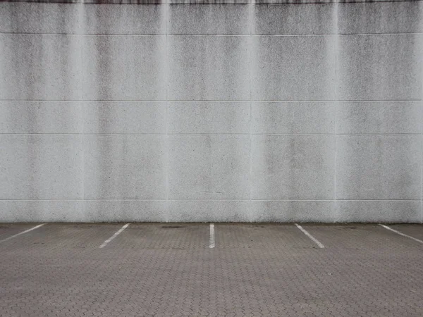 Pusty szary getta miejskiego parkingu ze ścianą — Zdjęcie stockowe