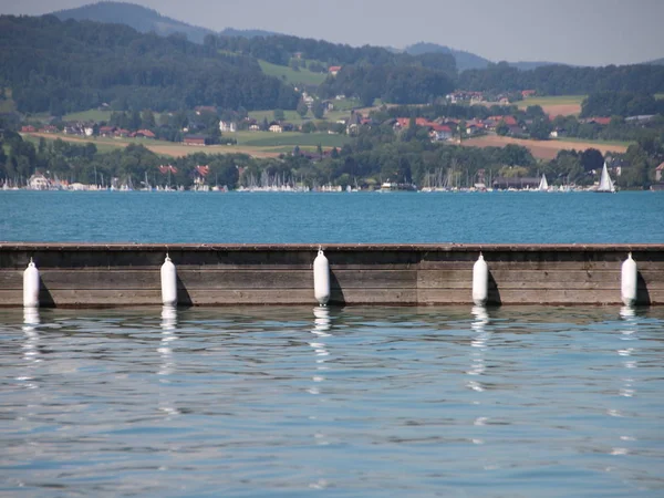 Wooden Pier with Five White Plastic Fenders on Water — Stock Photo, Image