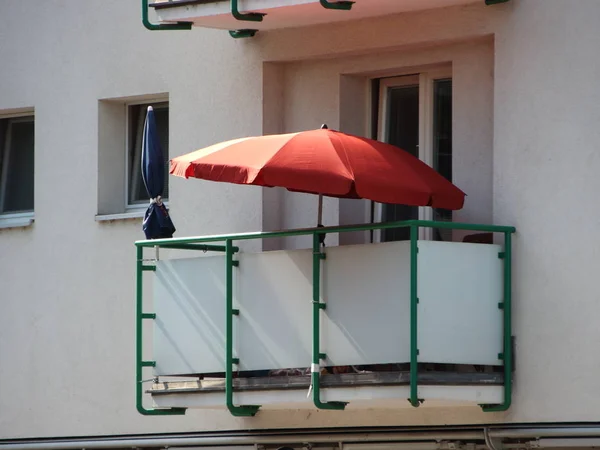 Ombrellone rosso singolo sul balcone in condominio — Foto Stock