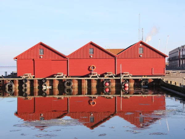 Bâtiments de pêcheurs rouges en hiver avec réflexion sur la glace — Photo