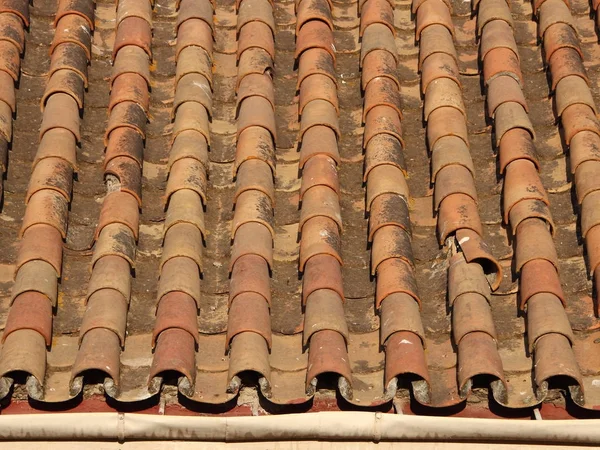 Vecchie mattonelle indossate Mattone tetto con grondaia in colori caldi — Foto Stock