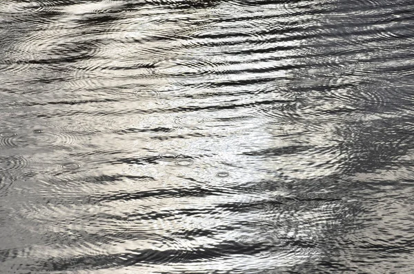 Background dark surface of the water. The texture of the water ripples. — Stok fotoğraf