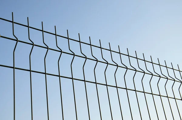 Geçmişi Mavi Gökyüzüne Karşı Metal Bir Çit Çitleri Yakın Çekin — Stok fotoğraf