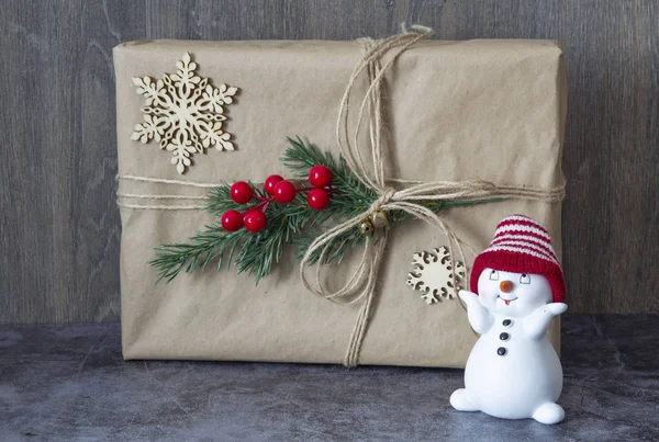 Packed Christmas gift with Christmas tree branch and red berries and Christmas toys