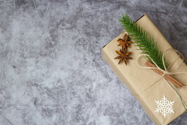 Noel hediyesi olarak koni, kırmızı böğürtlen ve kar taneleriyle süslenmiş köknar dalları.