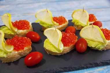 Kırmızı havyar bruschetta, tereyağı, marul ve vişneli domates.