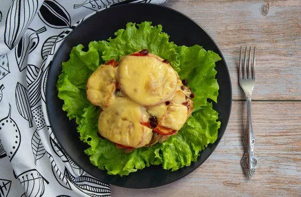 Peynirin altında mantarlı, fasulyeli ve domatesli tavuklu fileto salata yaprağı.