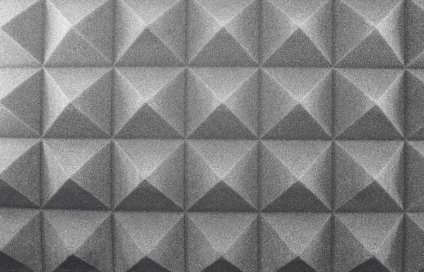 Noise absorbing material, soundproofing, sound acoustical foam. Foam, sponge, subwoofer, resonance for the recording room Music room, gray texture background. Details, close-up of triangles wall decor