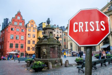 Stockholm, İsveç 'teki tarihi eski kasaba manzaralı kriz dur tabelası. Koronavirüs salgını yüzünden dünya ekonomisinde mali kriz. Küresel ekonomik kriz, durgunluk.