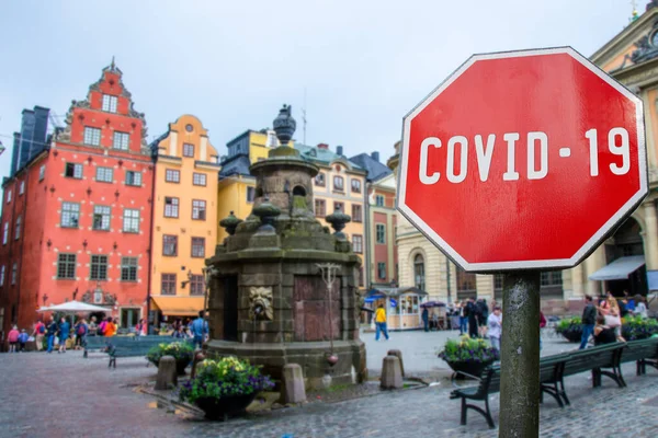 stock image Corona virus stop sign with view of historic old town in Stockholm, Sweden. Warning about epidemic quarantine. Coronavirus disease pandemic. COVID-2019 alert sign