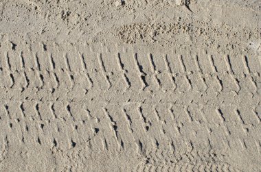 Sarı kumdaki lastik izi.