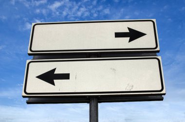Kavşak Yolu İşareti, Blue Sky arka planında İki Ok. Kopya alanı olan iki yol tabelası. Bir direkte iki ok farklı yönleri gösteriyor.
