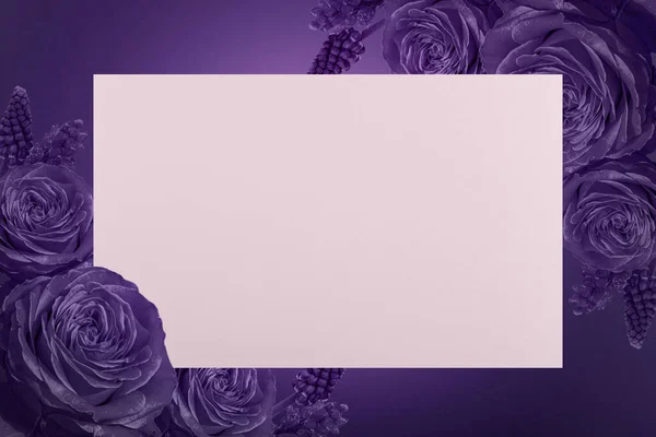 Rectangle card with purple flowers in the corners on purple background. Blank greeting card with copy space and assorted flowers frame with space for text. Holiday concept. Flower boarder.