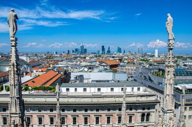 İtalya 'daki Milan Katedrali' nin (Duomo di Milano) çatısı panorama manzaralı. Porto Nuovo 'da modern gökdelenleri ve Duomo' nun taş heykelleri olan Milan gökdelenleri. Eski ve yeni.