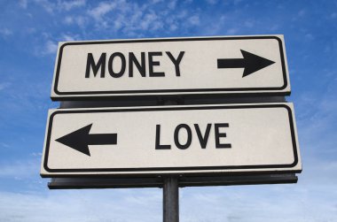 Para aşka karşı. Metal direğe ok saplanmış beyaz iki sokak tabelası. Yönlü yol. Kavşak Yolu İşareti, İki Ok. Mavi gökyüzü arka planı. Metinli çift yönlü yol işareti.