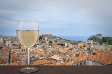 Hırvatistan 'ın Dubrovnik kentinde kırmızı çatılar manzaralı bir bardak beyaz şarap