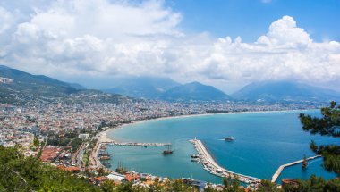 Ufukta bulutlar olan deniz yüzeyi ve arka planda dağlar olan son sınır kasabası.