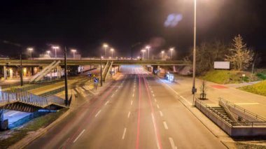 Yol, araba farları ve otobüs durağıyla şehirde güzel bir gece kaçamağı. İnsanlar otobüs durağında bekliyor.. 