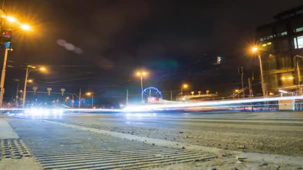 令人惊奇的是 夜幕降临在城市 有道路和汽车前灯 人们在人行横道上过马路 摩天轮旋转得很好 汽车在一个大城市的交叉口疾驰 — 图库视频影像