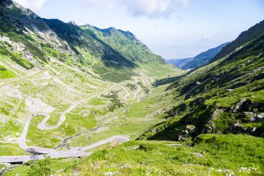 Dağ bölgesi ile sarma asfalt yolda güzel yaz sabahı sürüş. Ünlü Tranfagarasan road, Romanya.