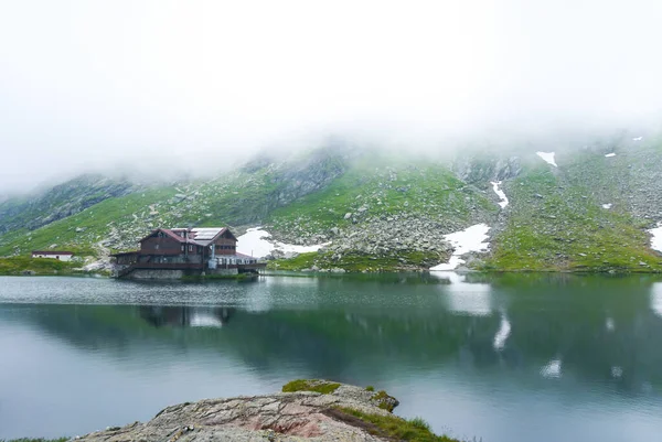 Majestic hose in fog, lake in mountains of Balea glacier lake near the Transfagarasan road. Location: Ridge Fagaras, Sibiu County, Romania, Europe