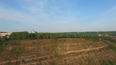 Katedralin altın kubbeleri, hava manzarası. İnanç kavramı. İnsansız hava aracının videosu. Kanyondan tepeye gidiyoruz. Küçük kasaba ve orman nerede?