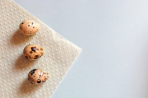 Bıldırcın yumurtaları mavi bir arkaplanda kağıt peçetenin üzerinde yatar..