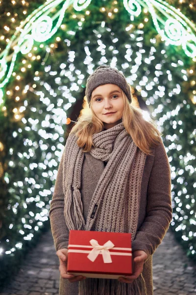 Ragazza in possesso di scatola regalo sul festival invernale. Donna felice con regalo di Natale su sfondo di Natale . — Foto Stock