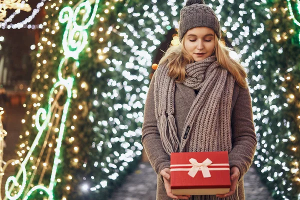 Ragazza in possesso di scatola regalo sul festival invernale. Donna felice con regalo di Natale su sfondo di Natale . — Foto Stock