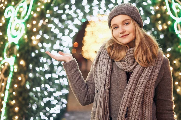 Una bella giovane donna o ragazza in piedi all'aperto di fronte a decorazioni natalizie . — Foto Stock