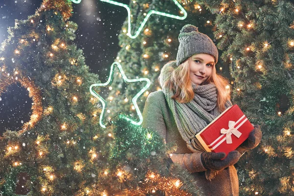 Ragazza in possesso di scatola regalo sul festival invernale. Donna felice con regalo di Natale su sfondo di Natale . — Foto Stock