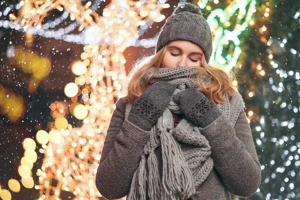 Ritratto di bella donna, vestita con abiti invernali, trascorre del tempo libero all'aperto, si erge contro scintille . — Foto Stock