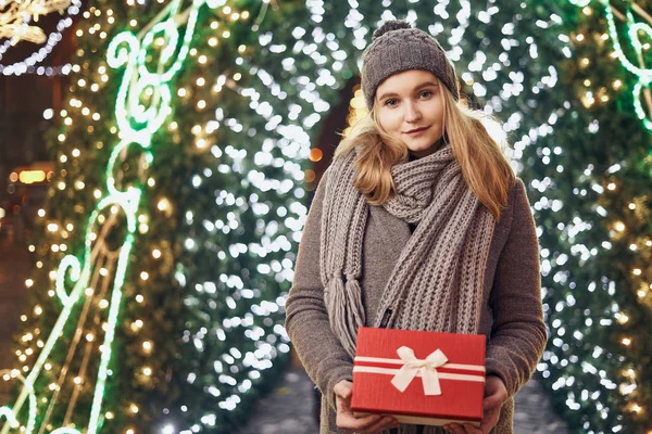 Ragazza in possesso di scatola regalo sul festival invernale. Donna felice con regalo di Natale su sfondo di Natale . — Foto Stock