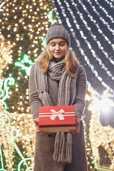 Ragazza in possesso di scatola regalo sul festival invernale. Donna felice con regalo di Natale su sfondo di Natale . — Foto Stock