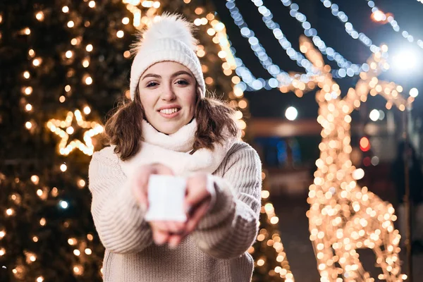 Girl hold hand warmers on night lights background.