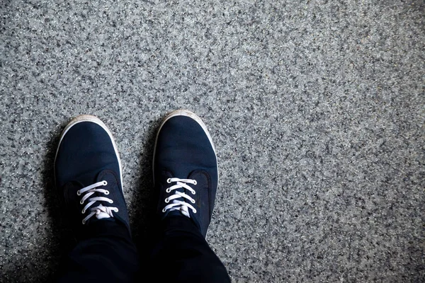 Taş üzerinde mavi spor ayakkabı.