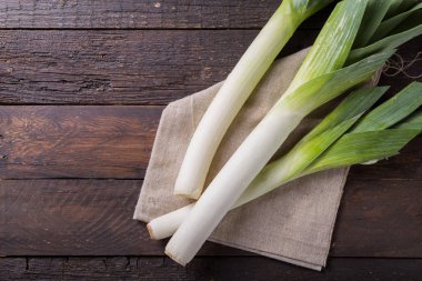 Fresh raw leek slices on wooden  background. Ripe onion clipart