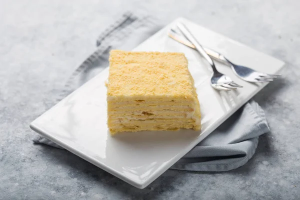 Pezzo di torta Napoleone su piatto bianco su cemento b — Foto Stock